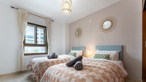 A hotel room with two beds, a window with curtains, a wall mirror, and a ceiling light. - Perfect Location 3 Bedrooms 2 bath, Parking, Pool REF048 (Fuengirola)