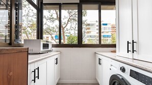 A compact laundry room with a washing machine, a microwave, and cabinets. - Perfect Location 3 Bedrooms 2 bath, Parking, Pool REF048 (Fuengirola)