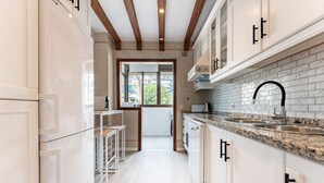 A modern kitchen with white cabinetry, a granite countertop, and a large window. - Perfect Location 3 Bedrooms 2 bath, Parking, Pool REF048 (Fuengirola)