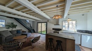 A modern kitchen with a central island, a dining area with a sofa and chairs, and a staircase leading to an upper level. - ANGE & LICE" HOUSE PERNES-LES-FONTAINES (Pernes-les-Fontaines)