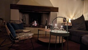 A cozy living room with a fireplace, a wicker chair, a sofa, and a table with a glass dome centerpiece. - ANGE & LICE" HOUSE PERNES-LES-FONTAINES (Pernes-les-Fontaines)