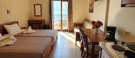 Une chambre d’hôtel avec deux lits, une table à manger, une machine à café et un téléviseur.