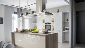Una cocina moderna con una isla central, electrodomésticos integrados y un diseño minimalista.