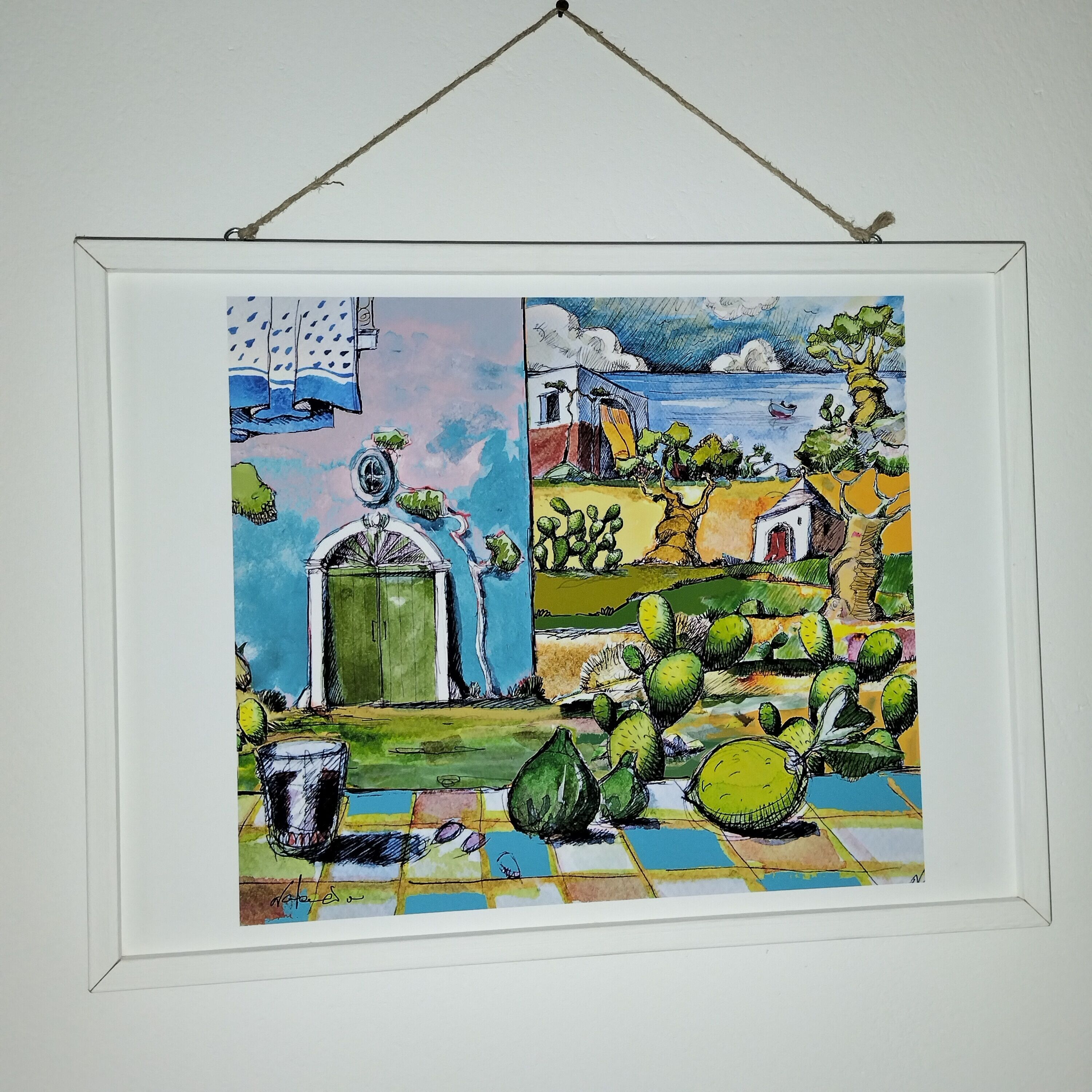 A framed artwork depicting a rural scene with a house, cacti, and a body of water.