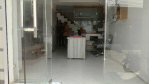 A reception area with a reception desk, a staircase, and a wall-mounted shelf. - Hotel Nue-Nest (Rishikesh)