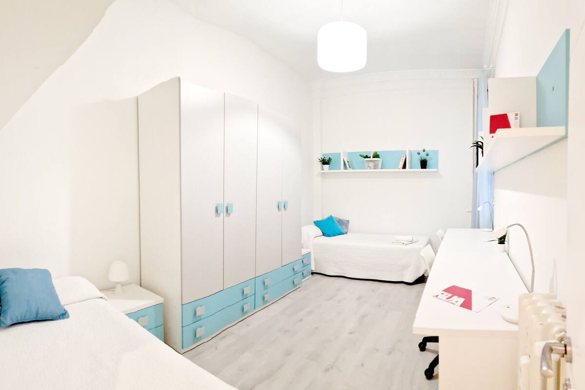 Une chambre à coucher moderne comprenant un lit, une table de chevet, une armoire et un bureau avec une chaise.