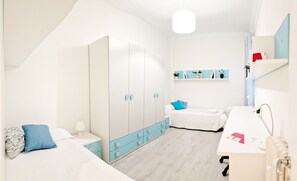 Un dormitorio moderno con cama, mesita de noche, armario y escritorio con silla.