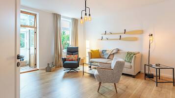A modern living room with a sofa, armchairs, a coffee table, and a floor lamp.