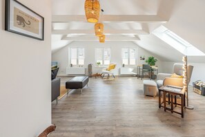 Un loft spacieux avec de hauts plafonds, un coin repas et un espace salon confortable.