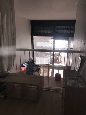 Enjoy a balcony with a street view, featuring a wooden bench and table.