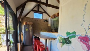 Eine Küche mit Holzbalkendecke, einer Karte an der Wand und roten Barhocker.