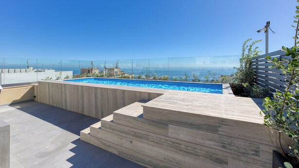 Una piscina en la azotea con vistas despejadas al océano.
