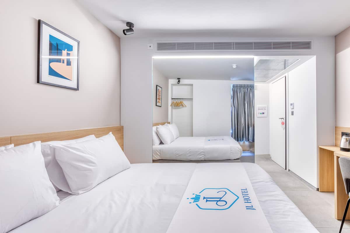 A hotel room with a bed, a desk, and a wardrobe.