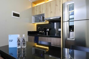 A modern kitchen with stainless steel appliances, wooden cabinets, and under-cabinet lighting.