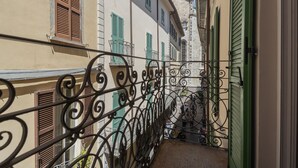 A narrow alleyway with buildings on either side, featuring wrought iron balconies and shutters. - Residenza Dolce Lago (Como)