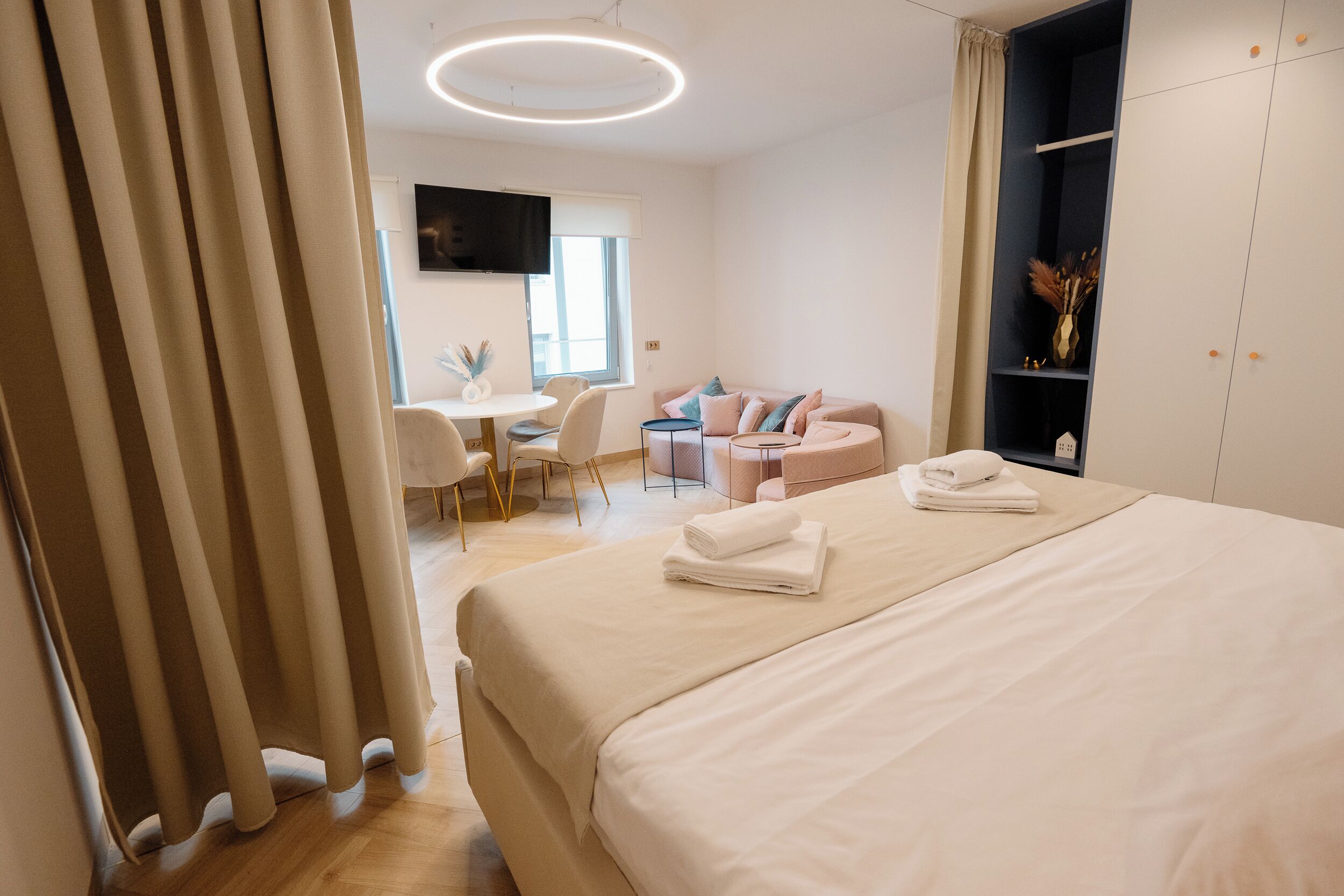 Een moderne hotelkamer met een groot bed, een bureau en een zithoek.