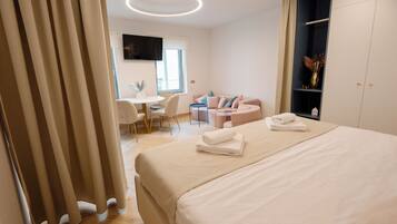 Een moderne hotelkamer met een groot bed, een bureau en een zithoek.