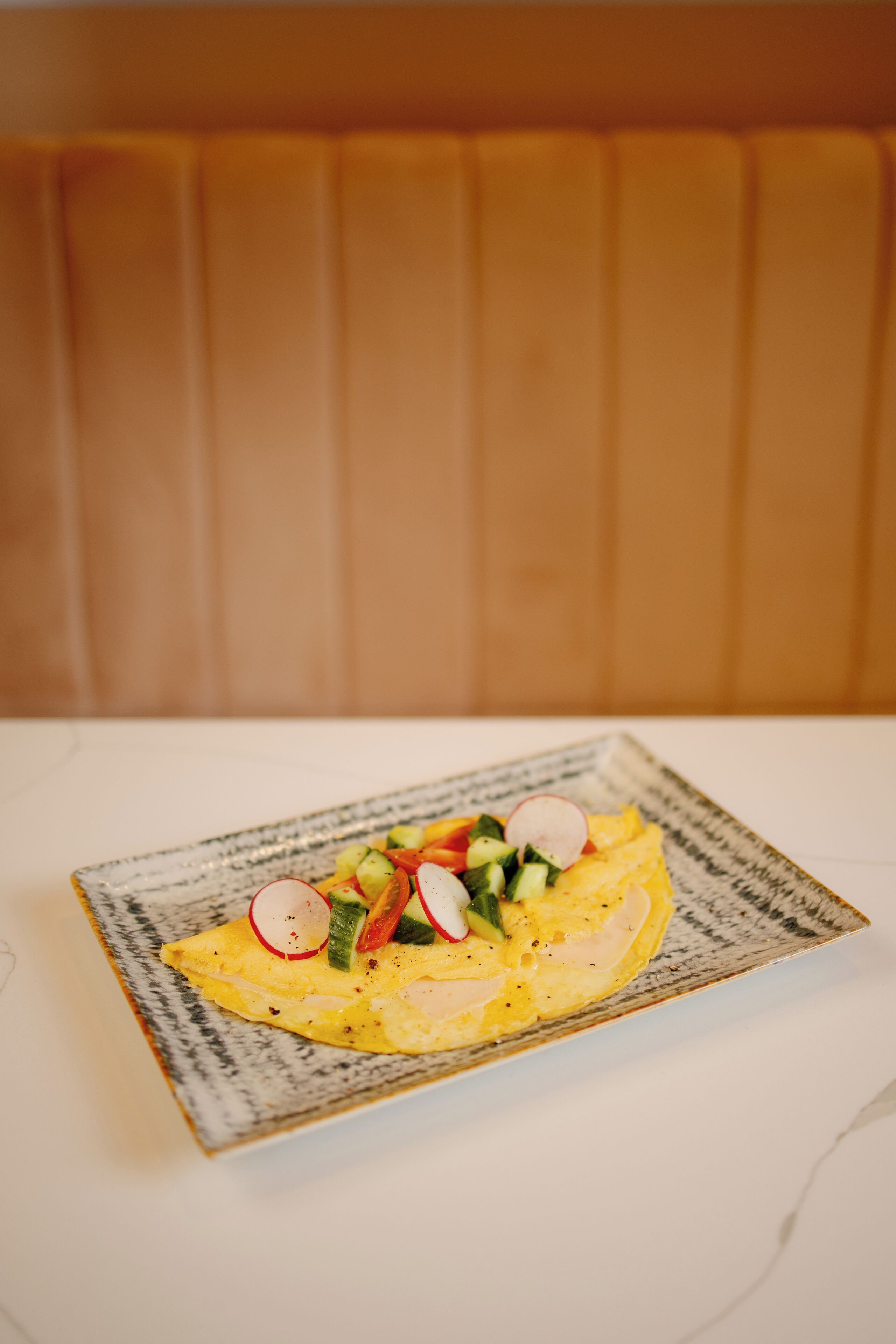A plate of food on a table with a patterned border.