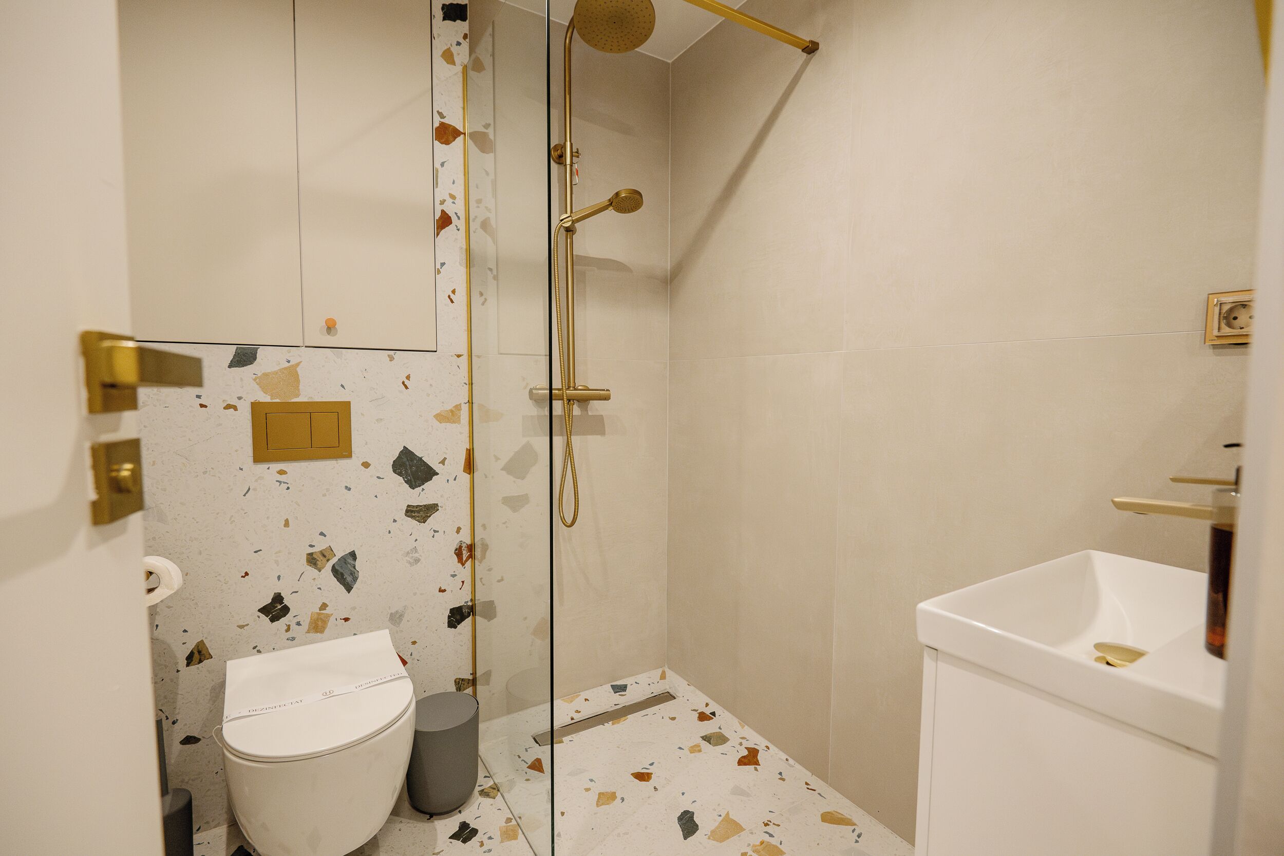 Une salle de bain avec douche, toilettes et lavabo.