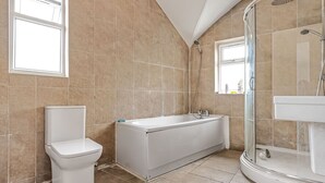 Ein Badezimmer mit Toilette, Badewanne und Dusche.