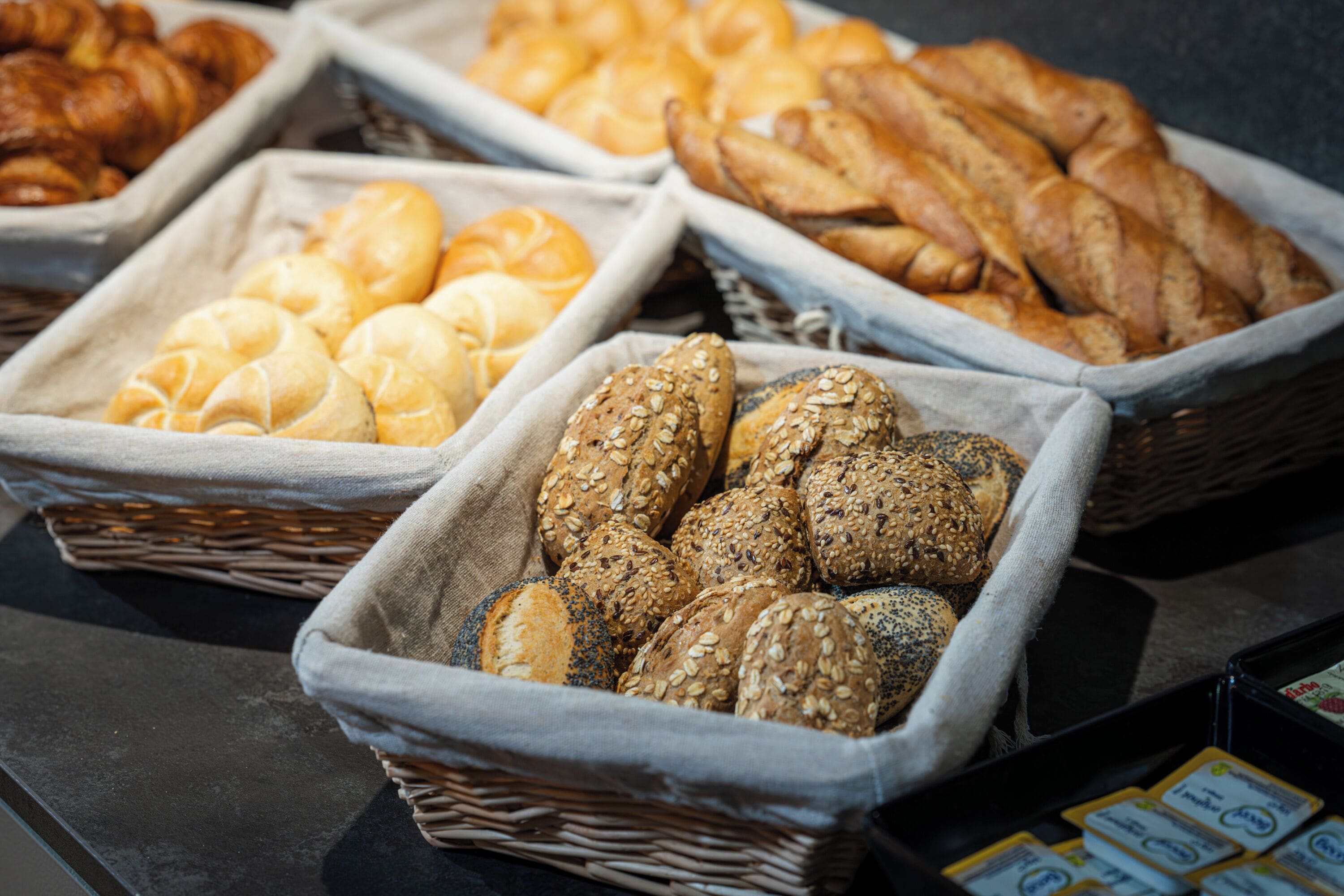 A variety of bread and pastries displayed in baskets.