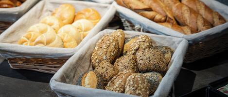 A variety of bread and pastries displayed in baskets.