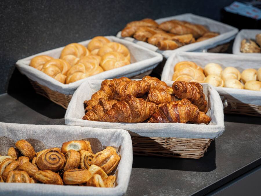Une variété de produits de boulangerie présentés dans des paniers sur un comptoir.
