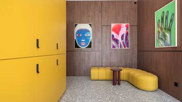 A modern room with a yellow sofa, a small round table, and wooden panel walls.