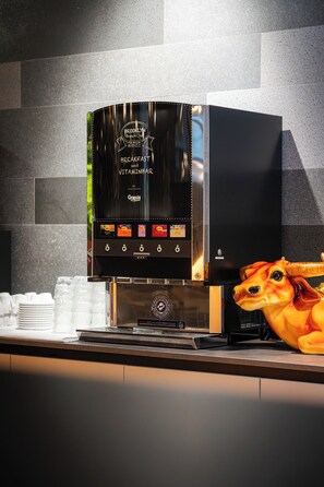 Una barra de desayuno con una máquina de café y una figura decorativa de vaca.