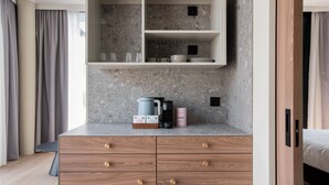 Una cocina moderna con encimera de granito, estante empotrado sobre el fregadero y mueble de madera debajo.