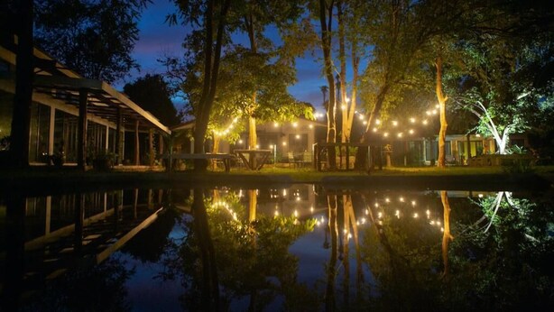 A serene lakeside setting with a wooden structure and string lights reflecting on the water. - Langkawi Rouhi Retreats at Langkawi (Langkawi)