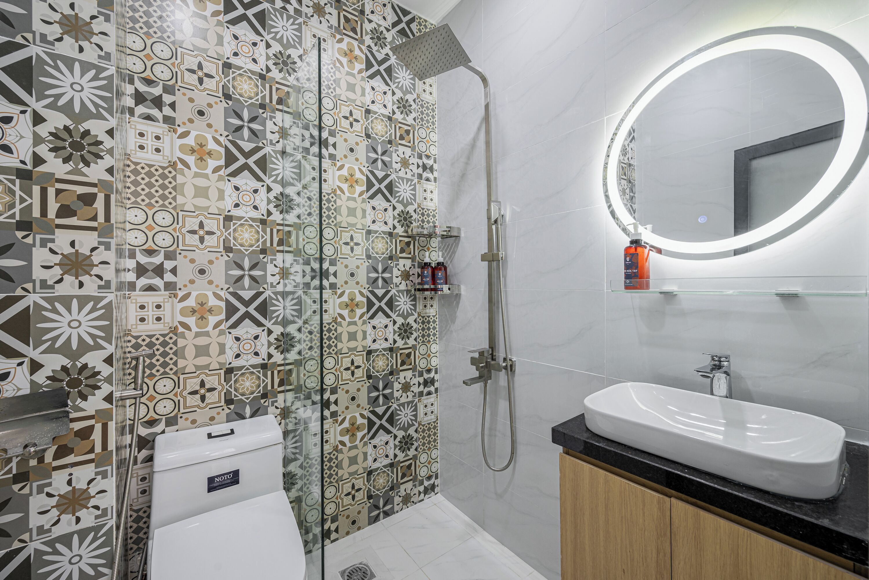 A modern bathroom with a shower, toilet, and sink.