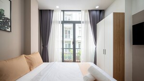 Una habitación de hotel con cama, televisor y vistas al exterior.