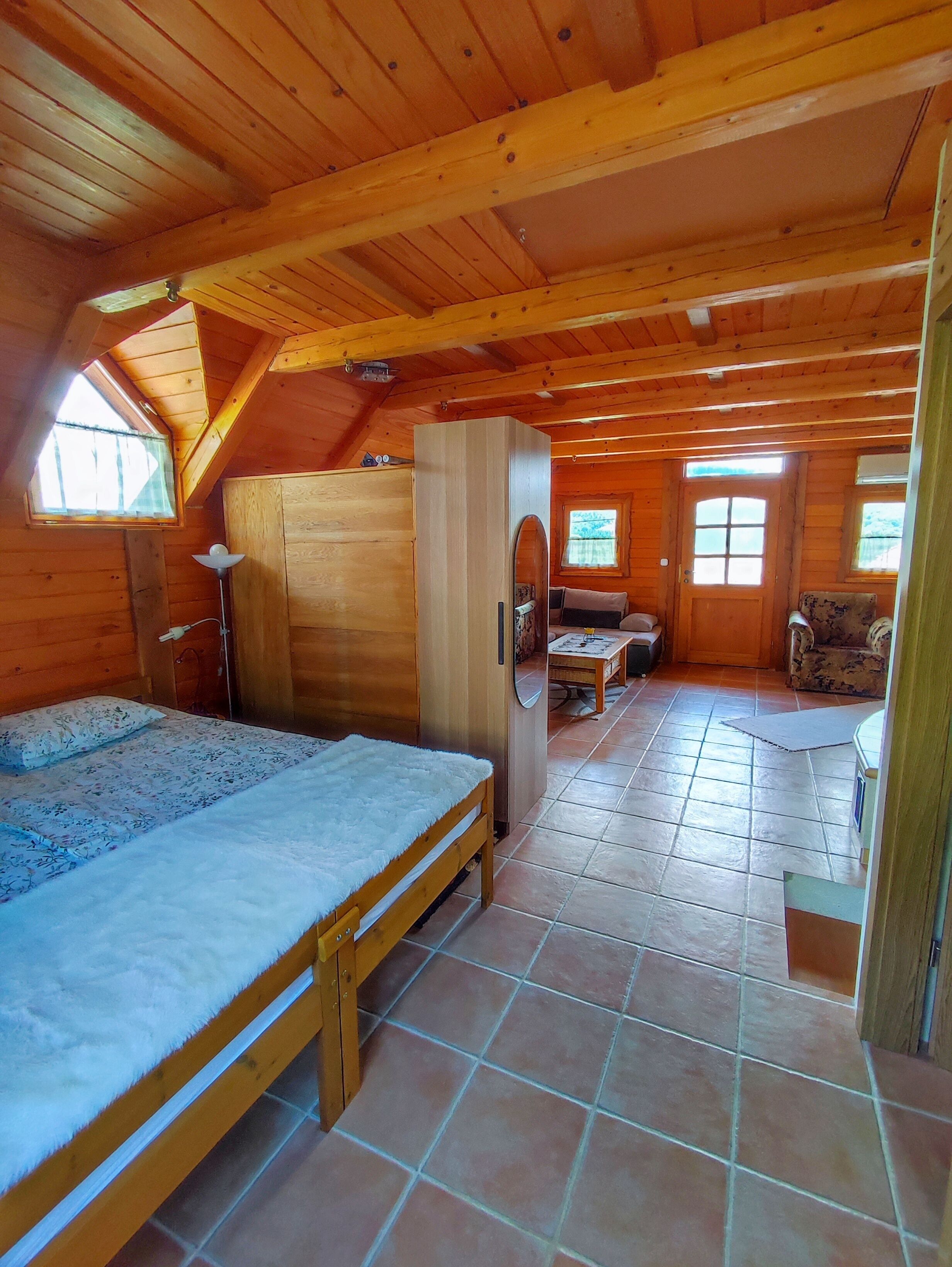 A cozy wooden cabin with a loft bedroom, a dining area, and a small living space.