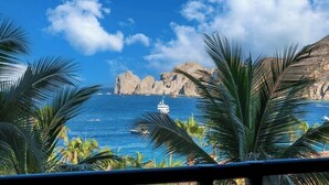 Vista costera con un promontorio rocoso y un barco a lo lejos.