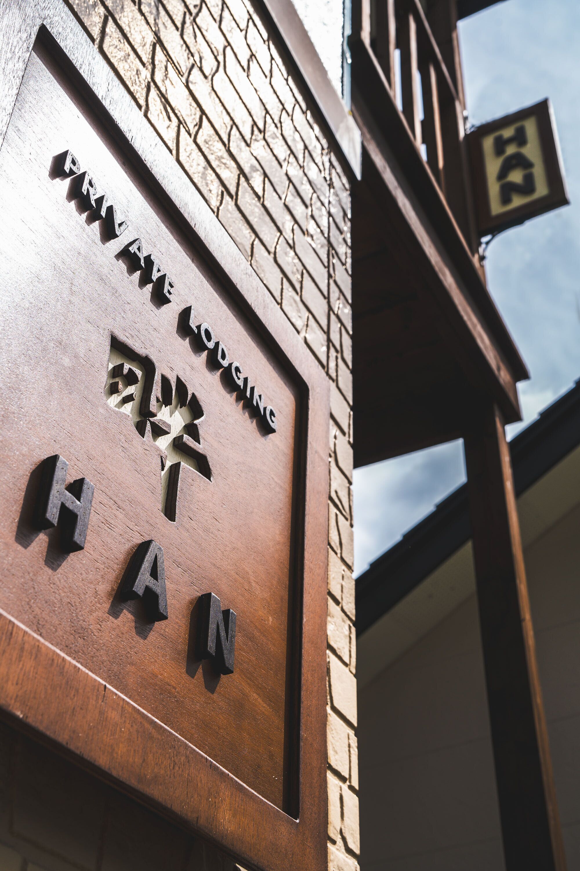 A wooden sign with "PRIVATE LODGING HAN" and Chinese characters.