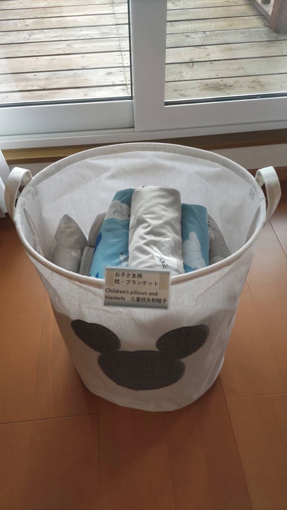 Ein Aufbewahrungsbehälter mit dem Hinweis, dass er Kinderkissen und Decken enthält.