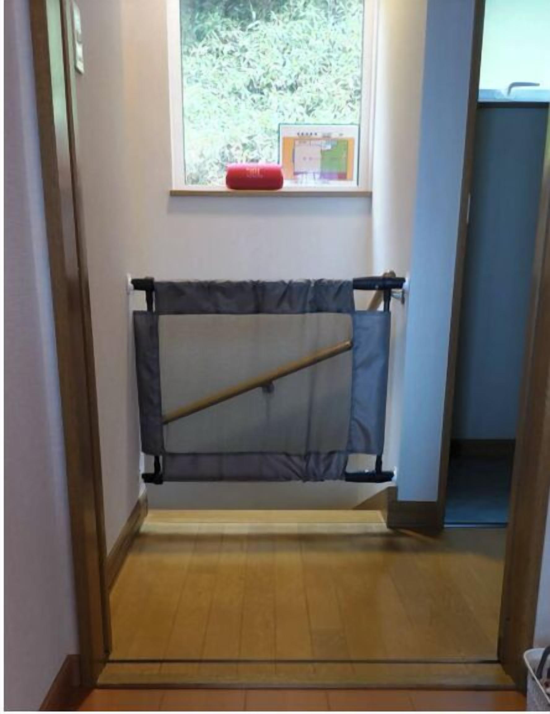 Una habitació amb finestra, porta i sòl de fusta.