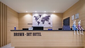 A hotel reception desk with a world map, a computer, and two plush rabbit figures. - Browndot Samcheonpo (Sacheon)