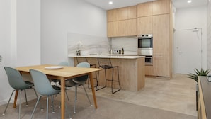 Une cuisine moderne avec des meubles en bois, un plan de travail en marbre et un four encastré.