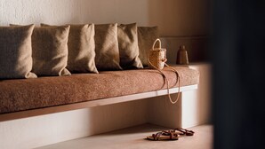 Un canapé avec des coussins marron et un panier tressé doté d’une anse.