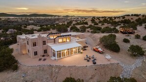 A modern villa with multiple rooms, a large glass facade, and a landscaped outdoor area with seating. - Indoor heated pool minutes to downtown Santa Fe (Santa Fe)