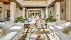 A spacious living area with a central coffee table, white sofas, and a large vase of flowers. - Indoor heated pool minutes to downtown Santa Fe (Santa Fe)