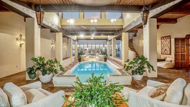 A spacious indoor pool area with a view of the sky, surrounded by white sofas and potted plants. - Indoor heated pool minutes to downtown Santa Fe (Santa Fe)