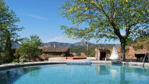 A clear swimming pool with a view of mountains, a tree, and a small building. - Historic Catalan country house located in a natural park and 40' from Barcelona! (Sant Llorenç Savall)