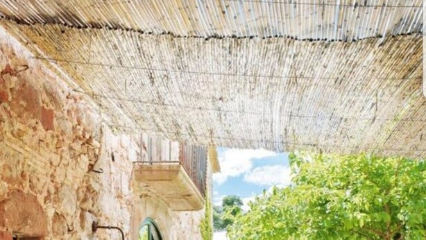 An outdoor seating area with stone walls, a table, chairs, and potted plants. - Historic Catalan country house located in a natural park and 40' from Barcelona! (Sant Llorenç Savall)