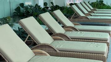 Relax in stylish wicker lounge chairs by a large window.