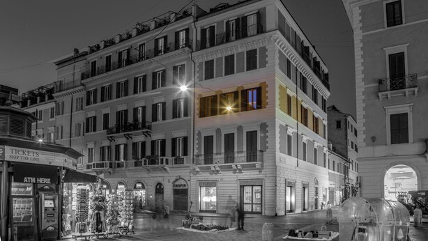 Un immeuble à plusieurs étages doté de balcons, d’un commerce au rez-de-chaussée et d’un distributeur automatique de billets bien visible.