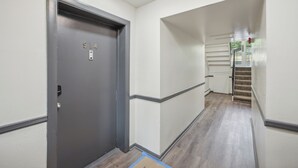 A hallway with a grey door marked "914" and a staircase leading to another floor. - Pine Brook 1302 I Pool Gym I Free Parking ! (Newark)