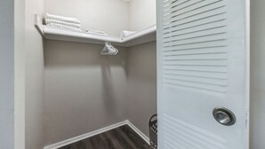 A corner closet with a white shelf holding folded towels and a basket. - Pine Brook 502 I Pool Gym I Free Parking ! (Newark)